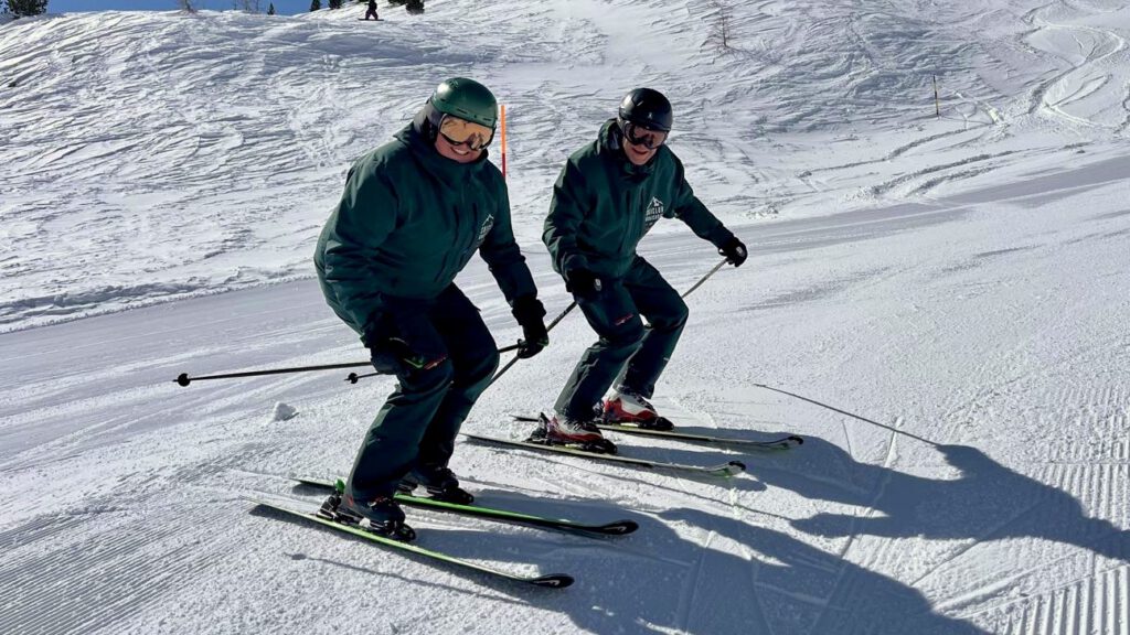 Ein Snowboarder erhält Skiunterricht